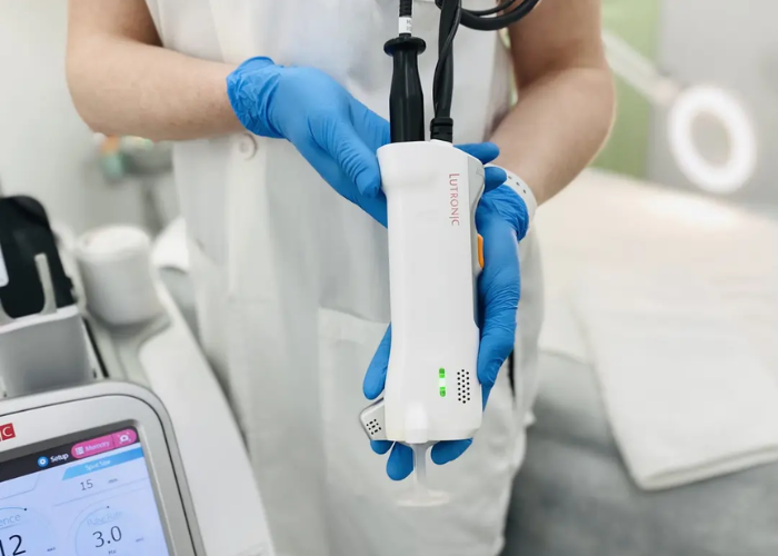 a photo of a lady holding the handpiece for the lutronic clarity II